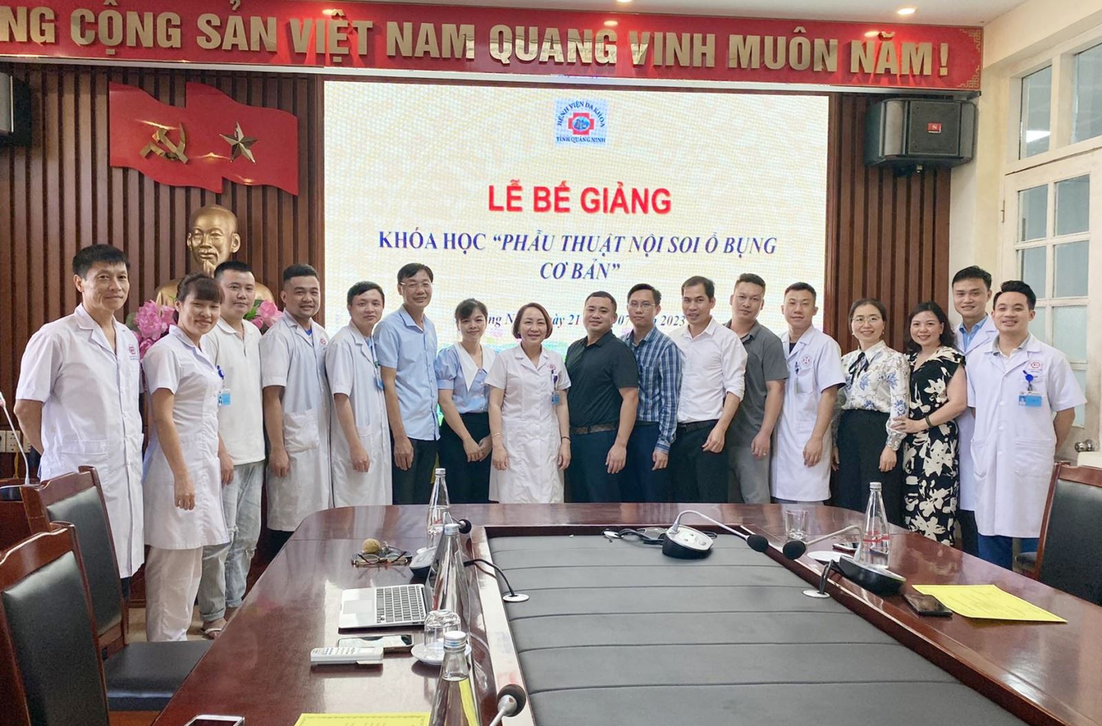 A group of people standing in front of a tableDescription automatically generated